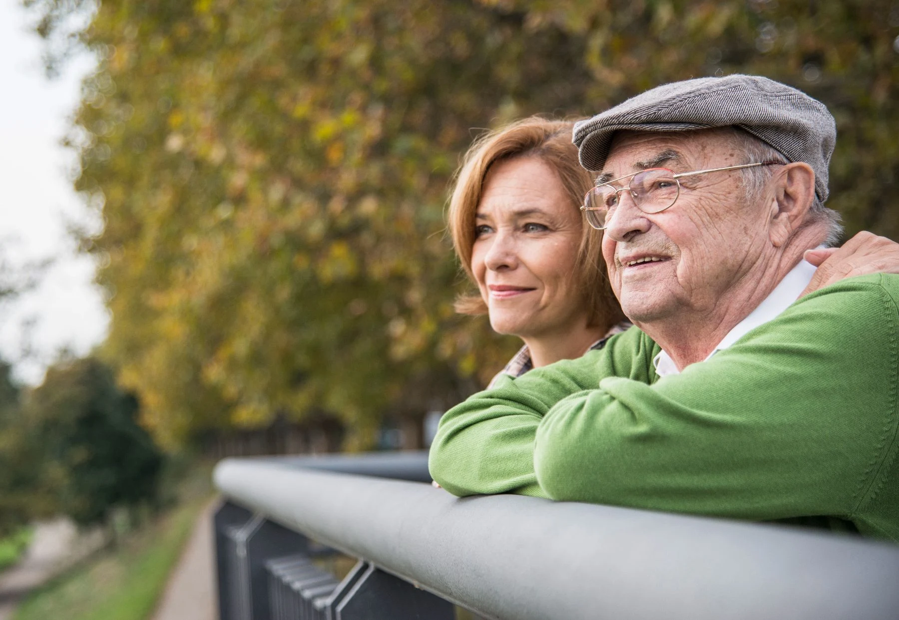 An older man and his daughter looking out across a park