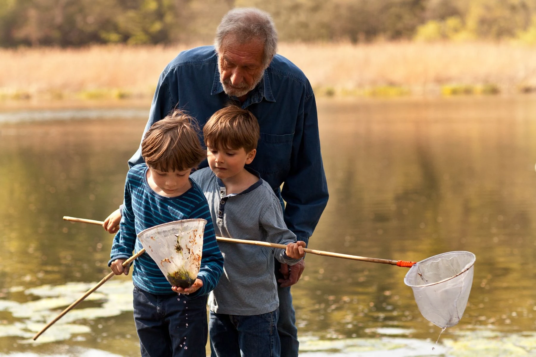 A grandfather at the water with two grandsons