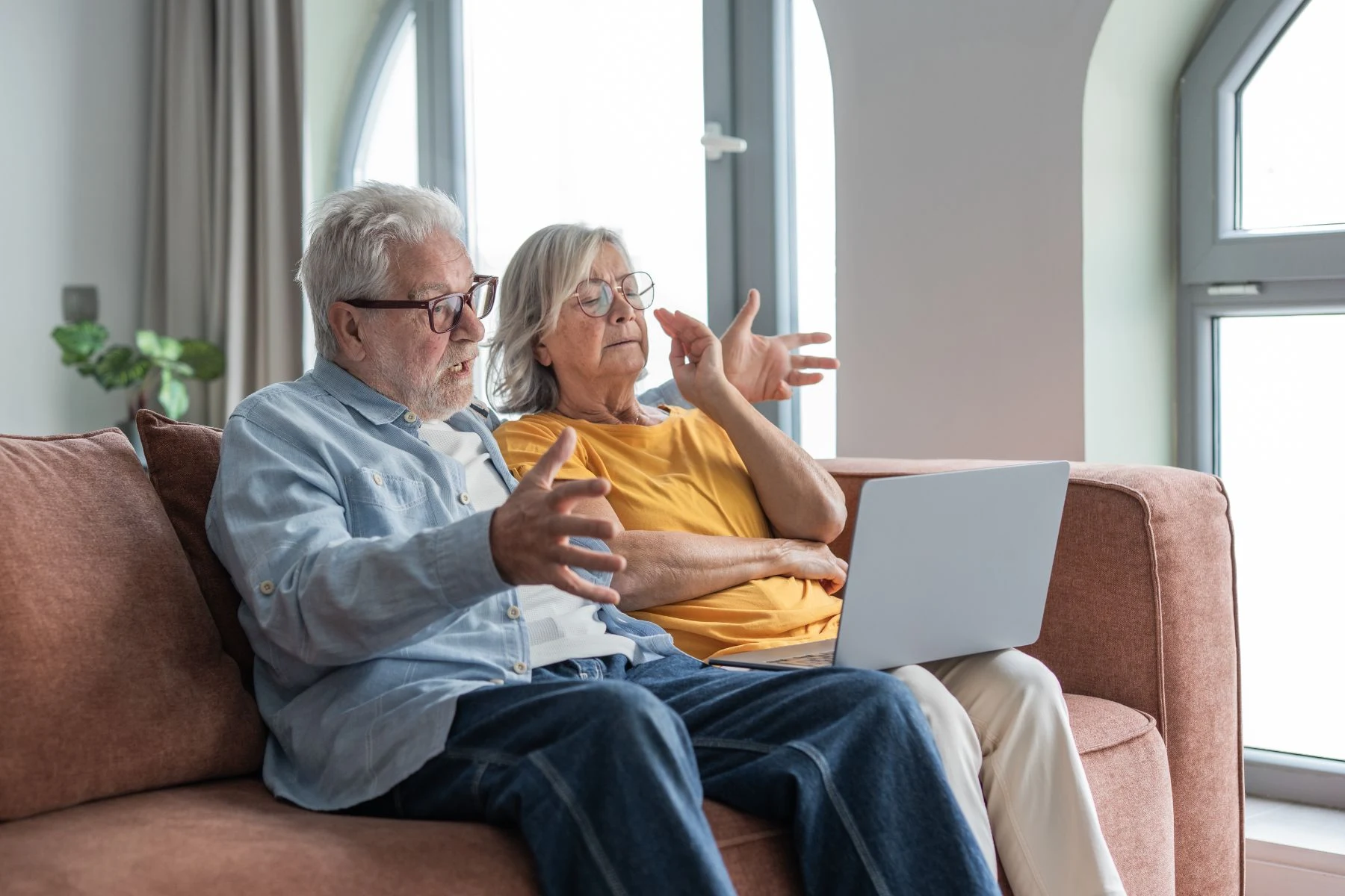 A couple reviewing information on a laptop at home