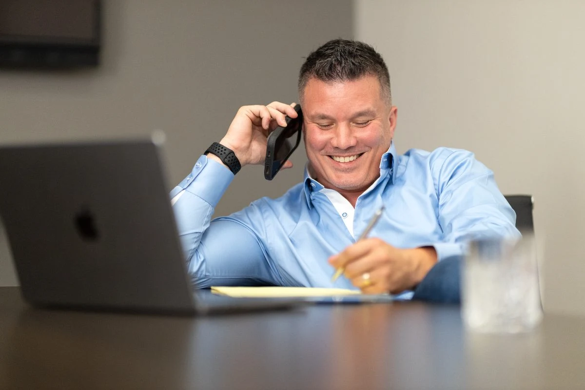 Dave Pulcini on a call at his desk, taking notes